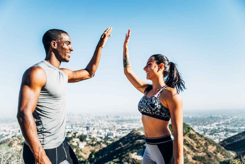 fit man and women high fiving after a run